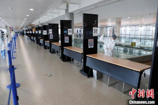 机场工作人员对候机楼公共设施处进行消毒。　殷立勤 摄