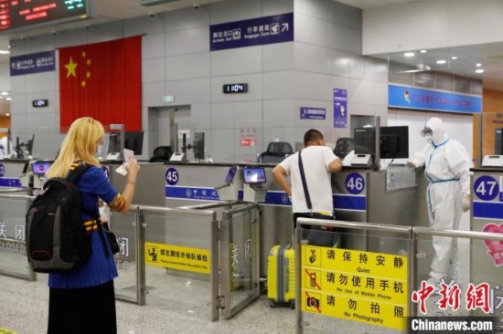 机场边检人员对入境旅客进行信息核查。　殷立勤 摄