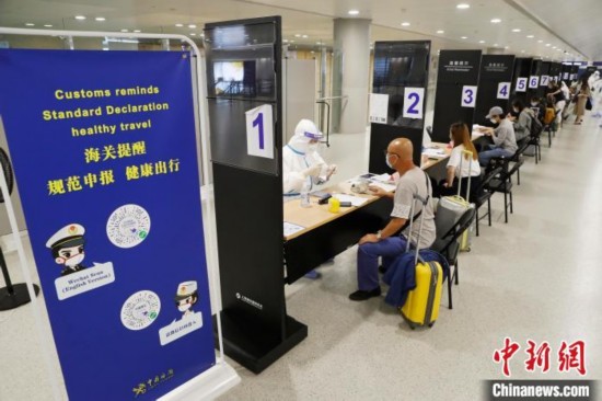 机场海关人员对入境旅客进行信息核查。殷立勤 摄