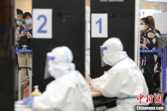 机场海关人员对入境旅客进行信息核查。　殷立勤 摄