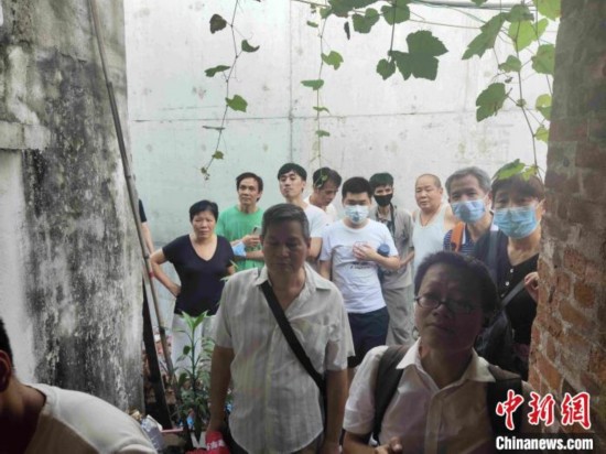 到梁女士家中围观的人越来越多。　姬东 摄