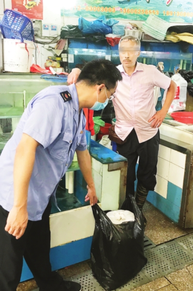 　　执法人员正在查处一家非法售卖活体河豚的摊位。　　（吴江检察院供图）