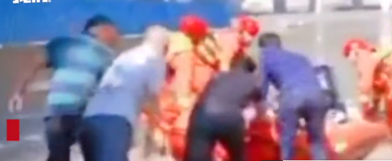 村民帮消防员把孕妇抬上橡皮艇。