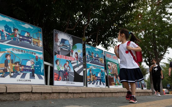 上地实验学校路口，交管部门设置了道路安全教育宣传牌，&ldquo;新小一&rdquo;的小朋友从旁边路过。摄影/新京报记者 李凯祥