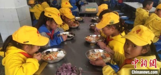 图为学生享受“三包”政策,在学校食堂吃上了免费营养餐。 尼玛江热乡中心小学供图 摄