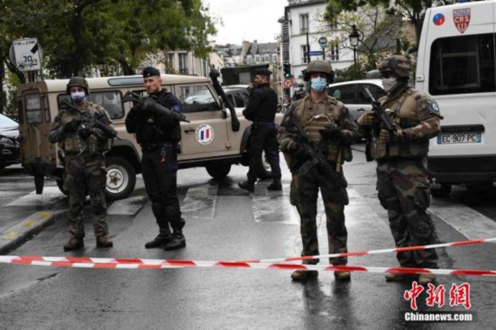 当地时间9月25日,法国首都巴黎发生持刀袭击事件。袭击发生于巴黎十一区的《查理周刊》总部原址附近。图为袭击事件现场戒备森严,法国防暴警察和宪兵持枪巡逻。 中新社记者 李洋 摄
