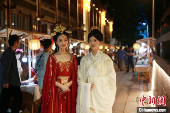 身着汉服的女子在福建省福州市鼓楼区善化坊藏天园文化夜市内缓步走来，众多游客、市民纷纷被这一幕吸引。藏天园文化夜市供图