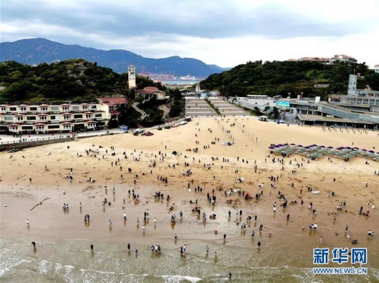 10月7日，游客在连云港市连岛大沙湾游乐园海滨浴场游玩（无人机照片）。新华社发（王春 摄）