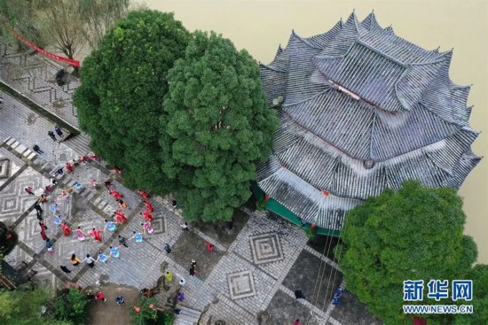 10月5日，在重庆市黔江区阿蓬江大峡谷神龟峡景区，演员和游客一起跳土家族摆手舞（无人机照片）。新华社发（杨敏 摄）