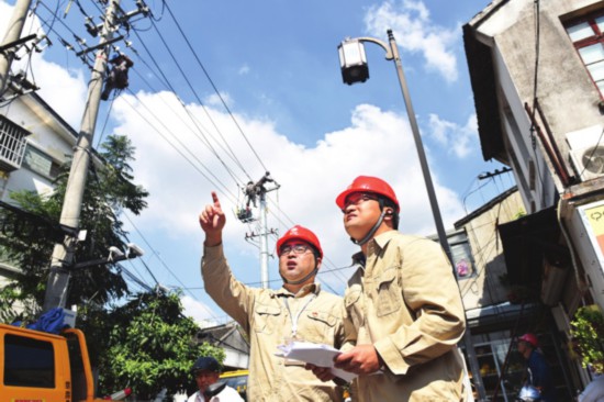 　　①杨启明（左）和同事现场踩点。