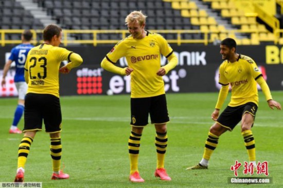 资料图:图为在多特蒙德与沙尔克04的比赛中,多特蒙德球员小阿扎尔进球后与队友“隔空”庆祝。
