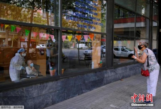 当地时间9月2日，西班牙巴塞罗那，一家养老院将老人推到玻璃窗前与前来探望的亲朋好友见面。