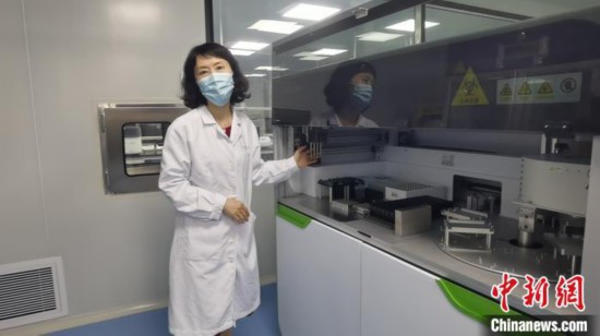 中山大学附属第八医院核酸检测实验室人员介绍检测设备情况。　郑小红 摄