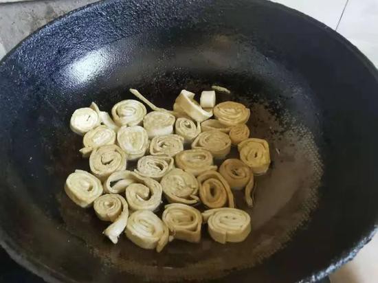 (图说:巴志强的家人寄来的武汉面食“臭千张”)