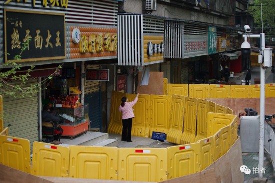 △ 2020年4月3日，商户在门前晾衣服，道路两旁立着围挡将商户与道路隔开。