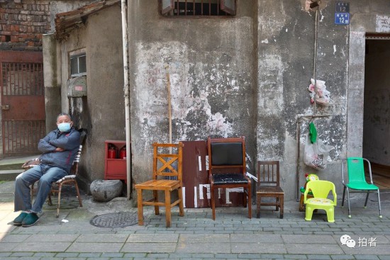 △ 2020年4月12日，老程独自一人坐在家门前，为街坊们准备的椅子还没人坐。