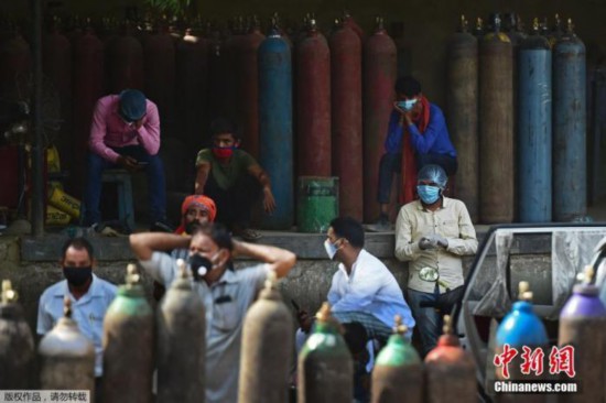 当地时间4月24日,印度新增确诊病例再创新高,连续第3天超过30万例。印度疫情蔓延导致多地医院出现供氧危机,许多医务人员、工作人员和普通民众都带着氧气瓶到氧气加气站。图为人们在阿拉哈巴德的氧气加气站等待加氧气。