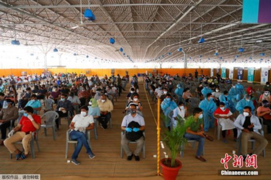 当地时间5月4日，印度新德里，人们带着防护口罩在疫苗接种中心等待接种印度自产的COVISHIELD新冠疫苗。据印度卫生部5月4日公布数据，过去24小时全国新增357229例确诊病例，累计达20282833例。这也是印度连续13天单日新增病例数在30万以上。