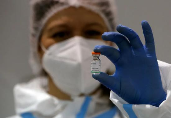2021年1月19日，塞尔维亚医务人员手持中国国药集团新冠肺炎疫苗。图源：视觉中国