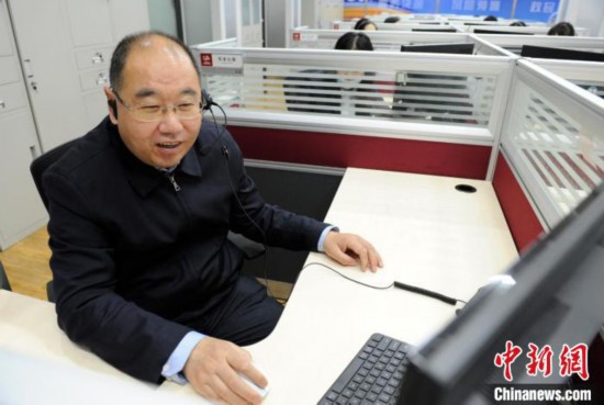 辽宁省营商环境建设局政策法规处一级调研员黄兴利在线接听群众咨询电话。　辽宁省营商局供图