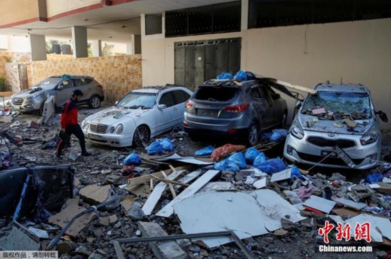 当地时间5月15日，巴以冲突期间，加沙地区当地民众走在空袭后的街道上。