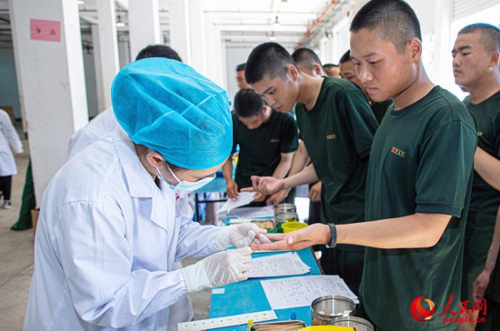 工作人员为新兵检验血型。