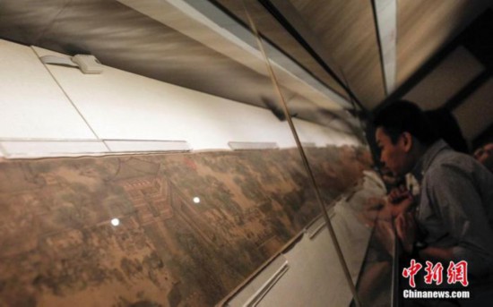 资料图：游客在北京故宫博物院观看石渠宝笈特展上的《清明上河图》。中新社发 张浩 摄