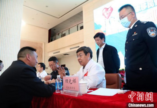 图为义诊专家组成员、中国中医科学院主任医师田元祥为西藏出入境边防检查总站民警诊断身体。　何宇恒 摄