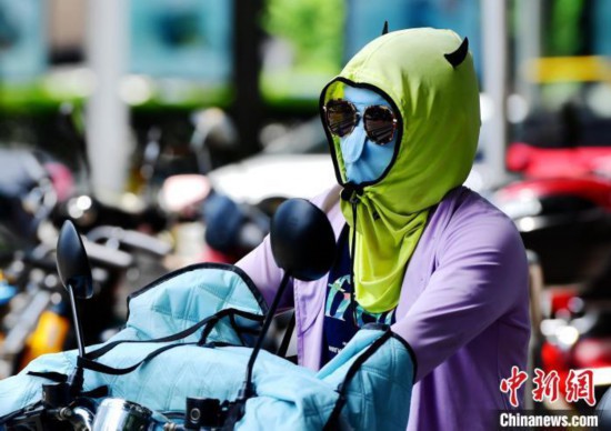 资料图：6月17日，福建福州市民烈日下&ldquo;全副捂装&rdquo;出行。张斌 摄