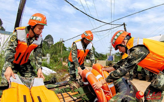 官兵在堤岸上集结，准备救援装备。