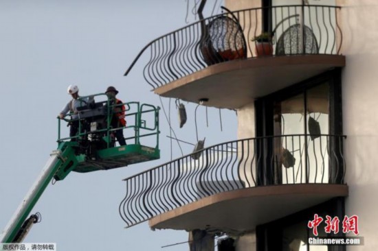 图为救援人员继续搜救坍塌高楼里的幸存者。