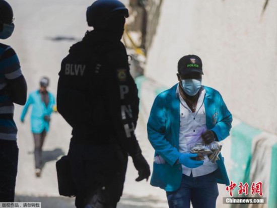 图为法医调查员带走一袋从海地总统住所收集到的弹壳。