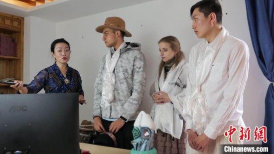 图为图为主播白玛旺姆为留学生介绍直播流程。 谢牧 摄