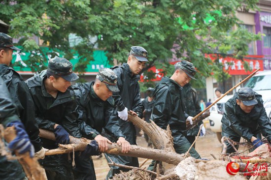 官兵正在河南巩义米河镇街道上清理杂物。