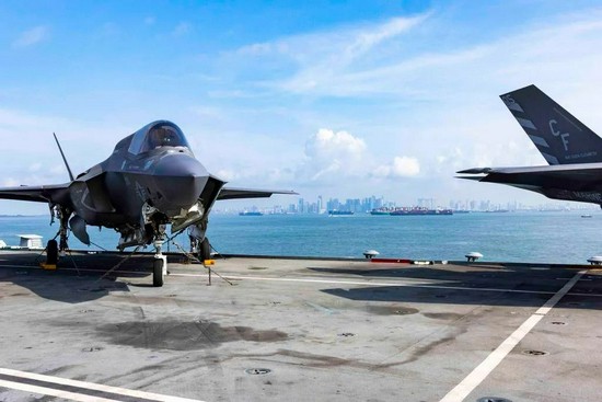 “伊丽莎白女王”号上的美制F-35舰载机，以新加坡城市为背景在马六甲海峡留影