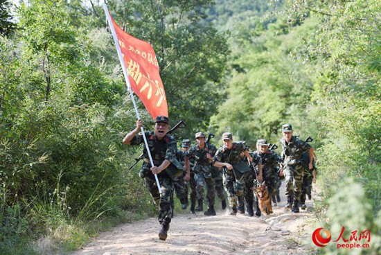 武警合肥支队执勤六中队官兵在烈日下进行山地五公里武装越野。