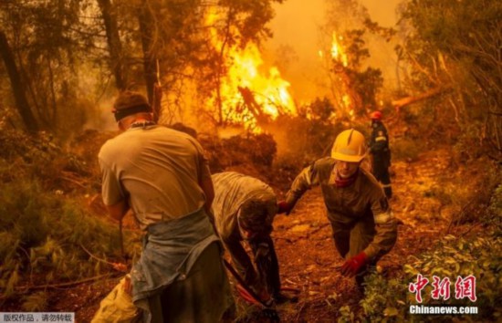 当地时间8月9日，希腊第二大岛屿埃维亚，消防员和志愿者正在梳理水管准备扑灭前方的山火。希腊当局已宣布受影响地区进入紧急状态。希腊总理米佐塔基斯形容称，这是一个&ldquo;噩梦般的夏天&rdquo;。