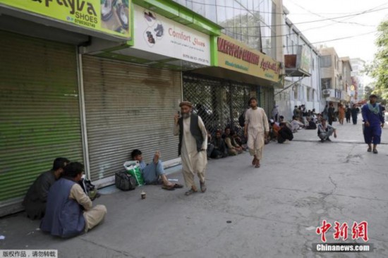 当地时间8月15日，阿富汗首都喀布尔，民众在一个集市排队，等待从附近银行取钱。