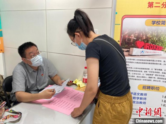 27日,2021年北京市中小学教师专场招聘会举办,图为应聘者与学校负责人交流。 徐婧 摄