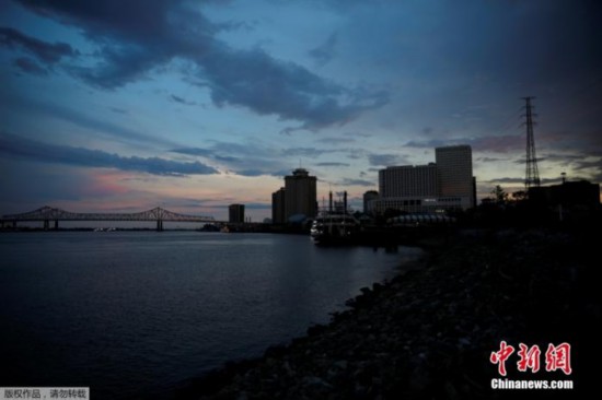 当地时间8月31日,美国路易斯安那州新奥尔良,由于电力尚未恢复,傍晚时分城市街景灯光罕见。