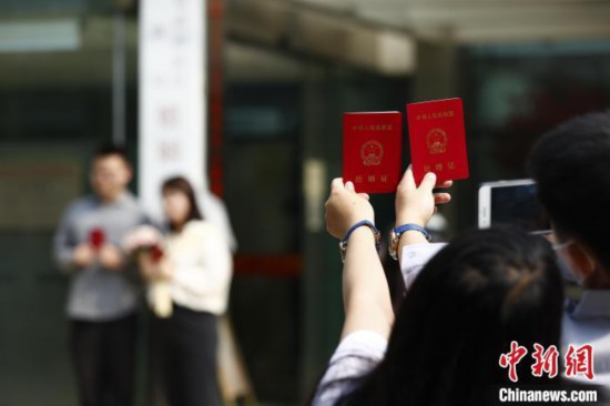 资料图：5月20日上午，北京市海淀区婚姻登记处外领证自拍的新人。 富田 摄