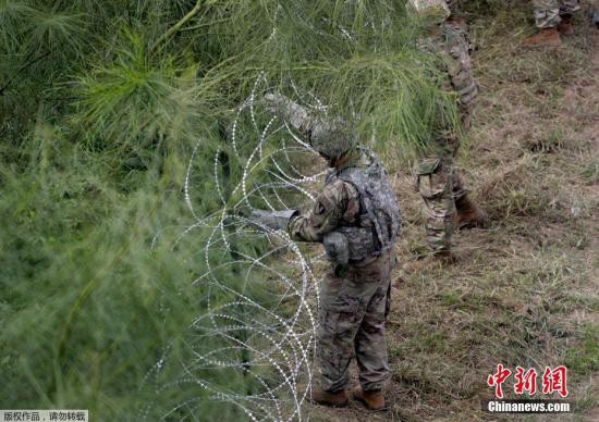 资料图：美国士兵在美墨边境安装铁丝网严防移民入境。