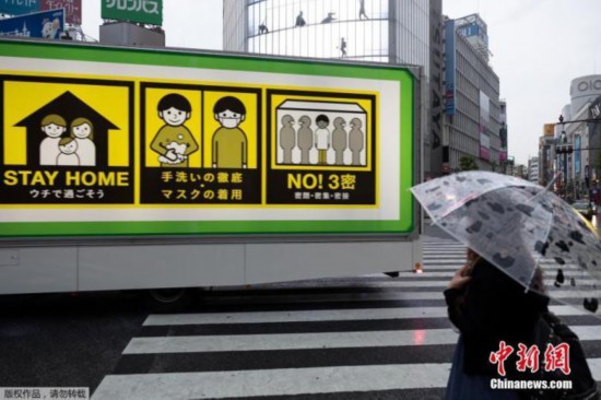 资料图。图为一辆装有新冠肺炎病毒预防措施屏幕的卡车驶过东京涉谷路口。