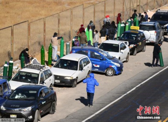 资料图：秘鲁新冠肺炎患者家属排队给氧气瓶充电。