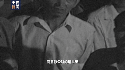  △黄会员的葬礼上，村民们高举手臂大喊“继续修路”。