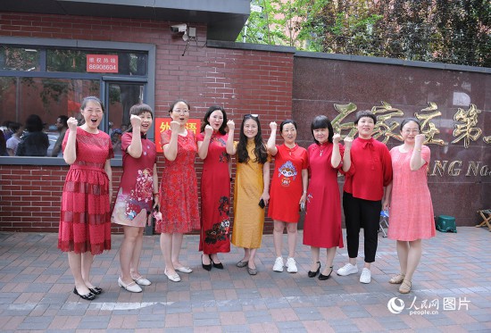 6月7日，在石家庄第二十七中学考点，家长身着旗袍，为高考的孩子们加油助威！红红火火、旗开得胜！人民网记者 周博摄