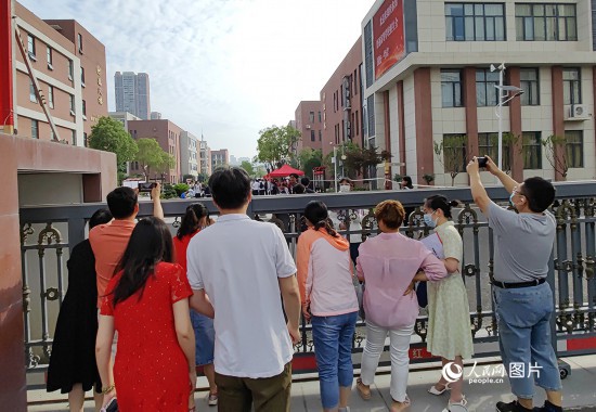 6月7日，武汉市第三中学考点，考生进场后，家长在栅栏外用手机拍摄自己的孩子。人民网记者 郭婷婷摄