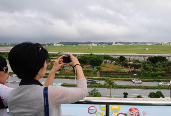 2010年5月18日，一名女子在日本冲绳县嘉手纳町远观美空军驻冲绳嘉手纳基地。新华社记者季春鹏摄