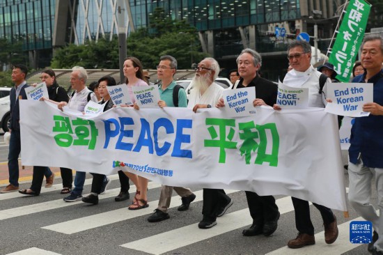 7月22日，在韩国首尔，东说念主们手举标语参与反战游行。新华社发（杨畅 摄）