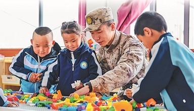 新疆军区某团组织开展&ldquo;民族团结一家亲&rdquo;活动。图为在驻地村庄幼儿园，一名战士和小朋友们一起拼积木。袁存皓摄